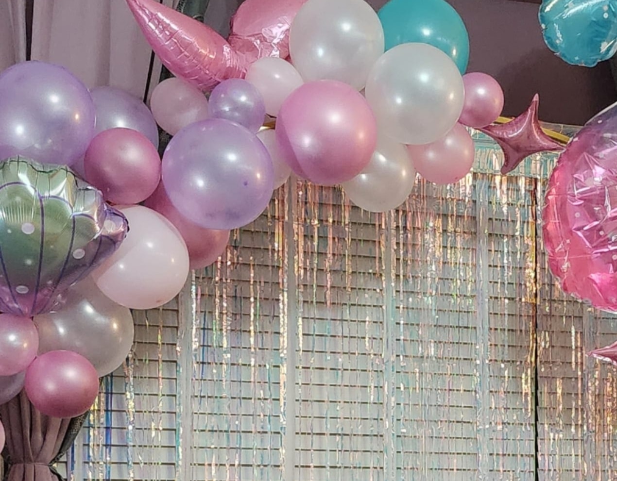 Colourful balloon arch backdrop at a party event