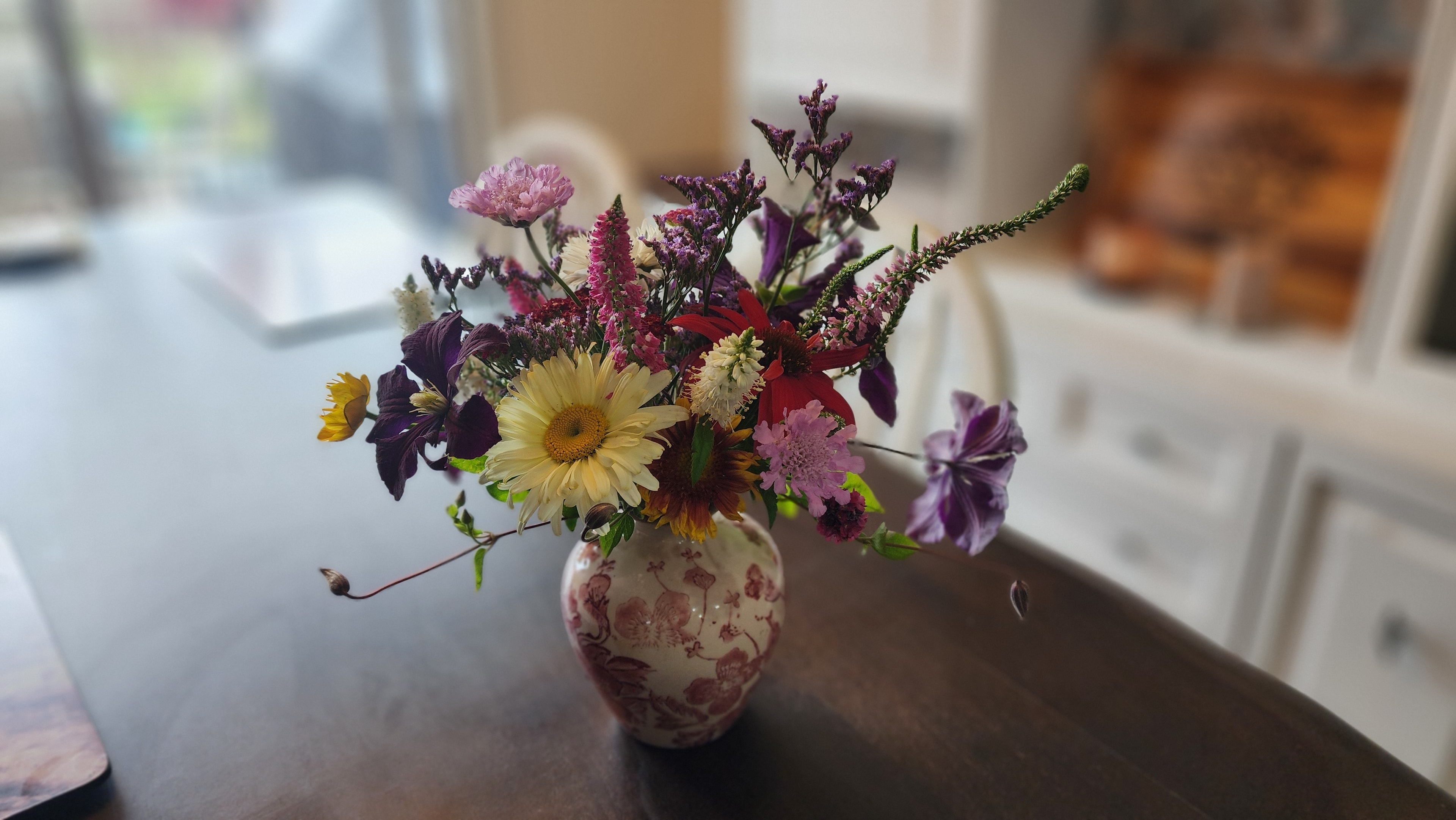 Seasonal flower subscription arrangement on kitchen table